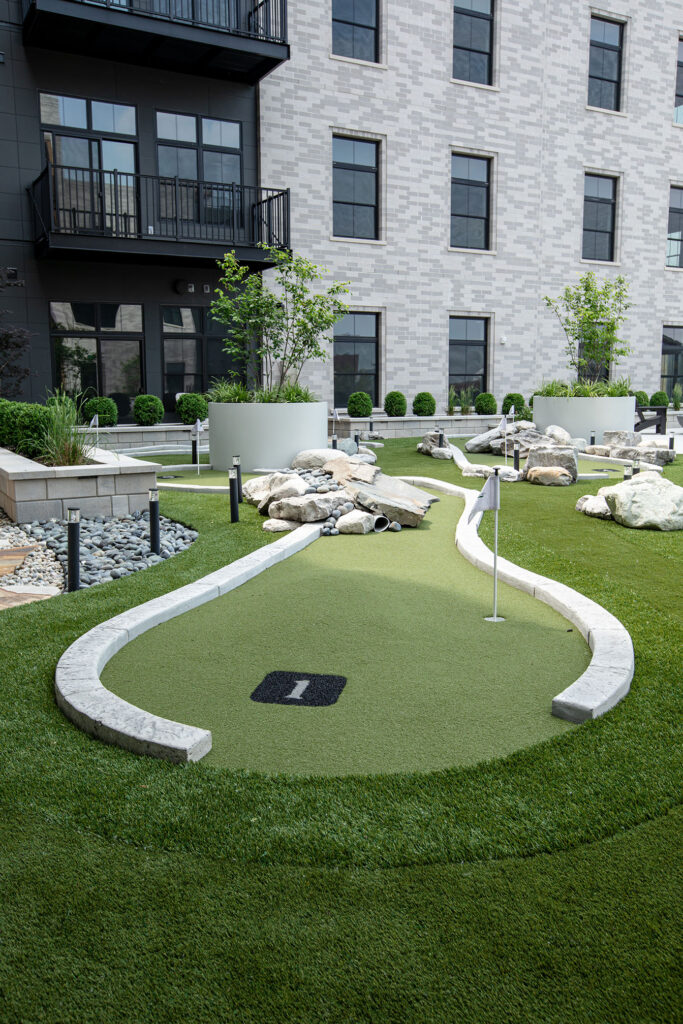 Rooftop mini golf and lounge area at The Pearl with skyline views of downtown Fort Wayne
