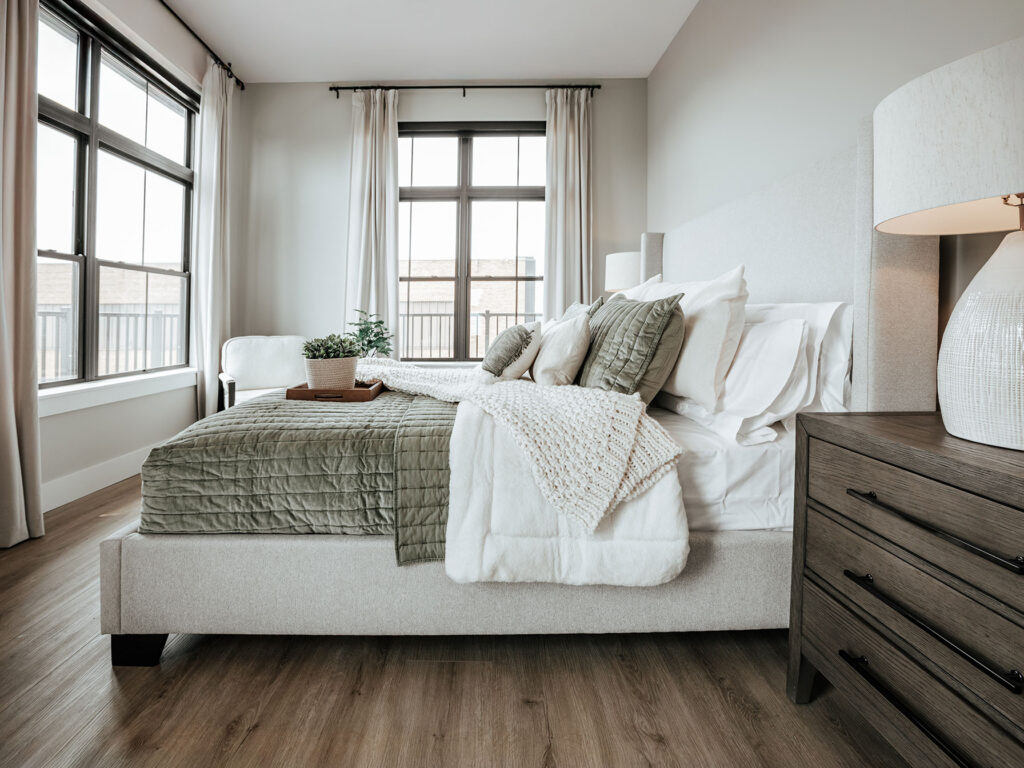 Cozy Pearl bedroom with oversized windows, neutral colors, and contemporary lighting in a Fort Wayne apartment